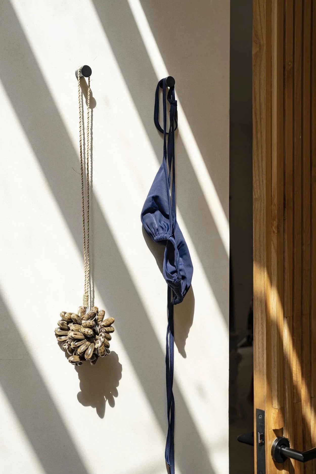 Bikini bleu marine suspendu sur un crochet mural pour la décoration naturelle