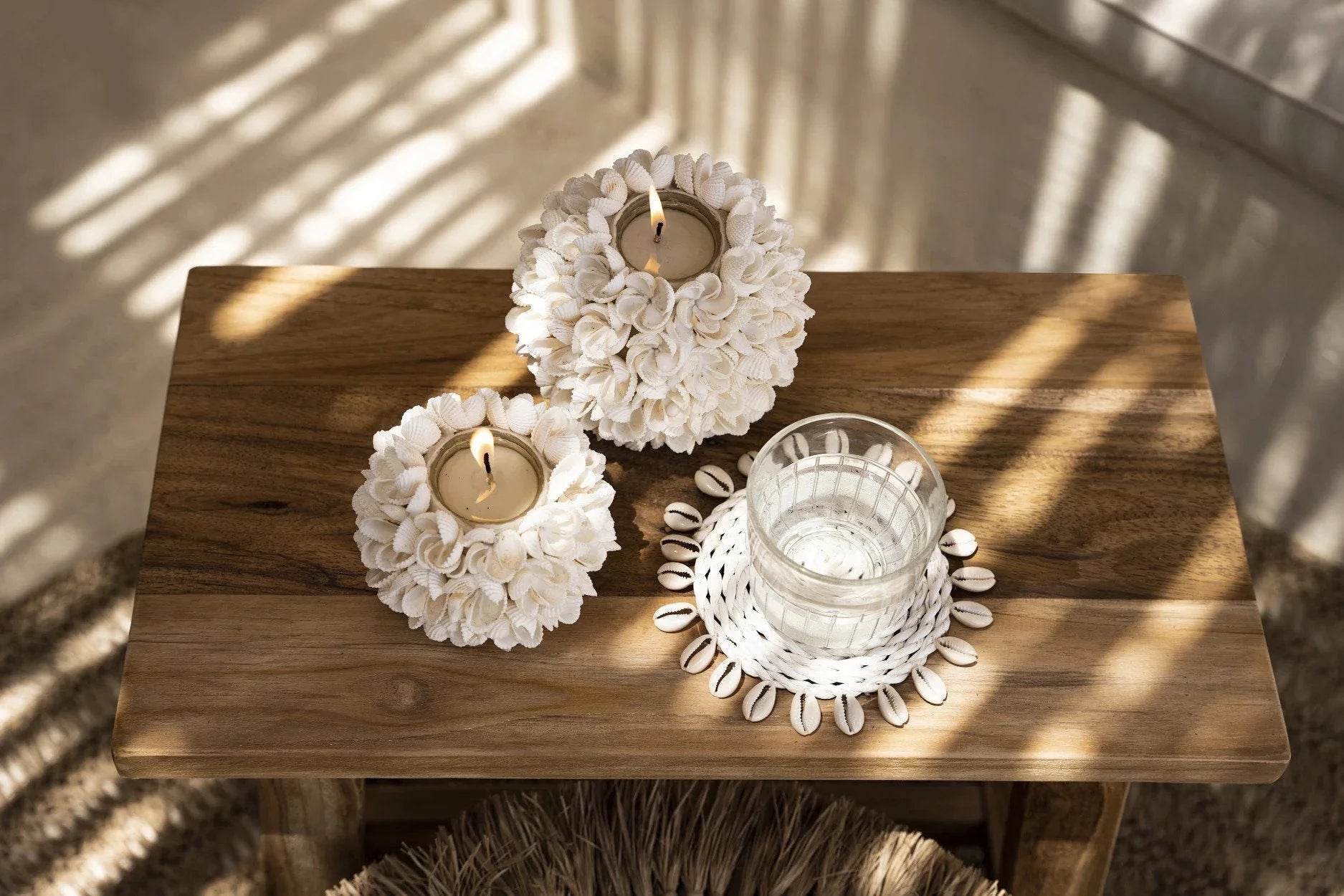 Porte-bougie floral blanc en coquillages sur table bois rustique