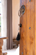 Porte-clés en bois avec coquillage marron, pompon noir et laiton