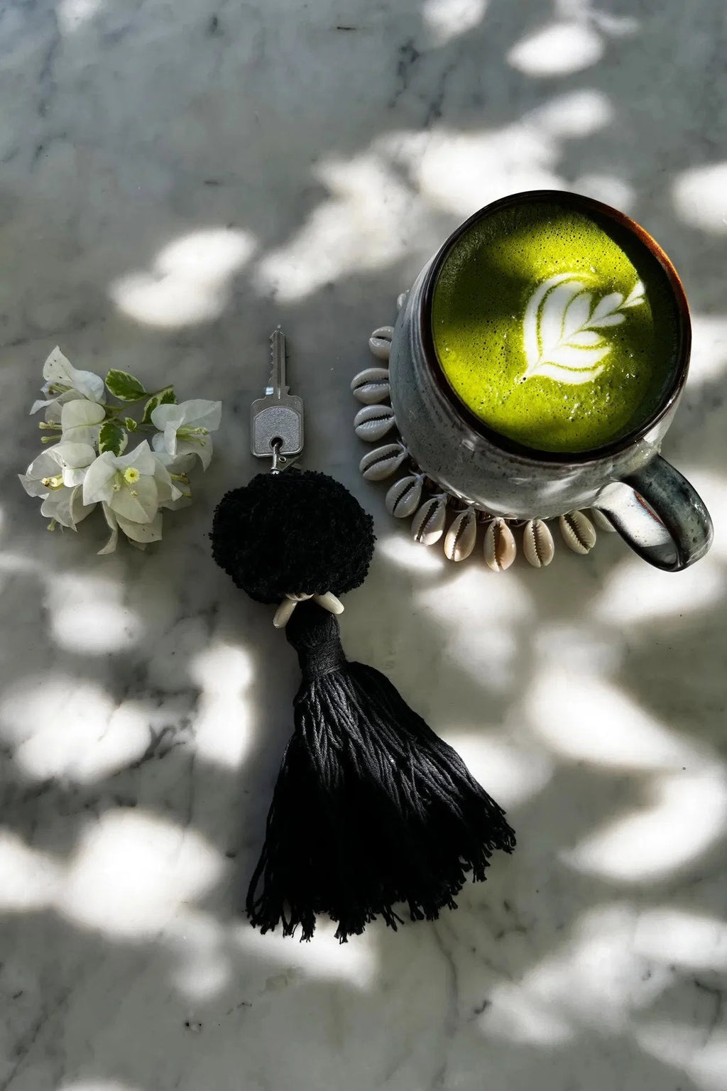 Latte matcha vert foncé en mug céramique à motif feuille sur coquetier coquillage