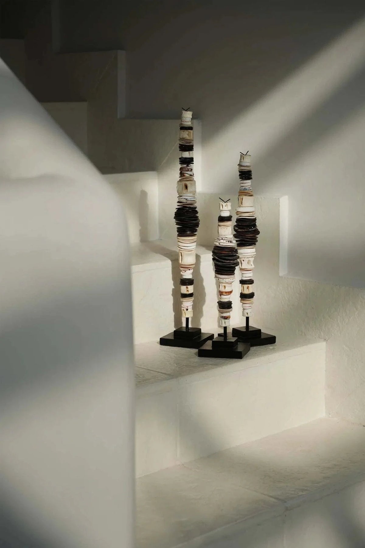 Trois totems sculpturaux élancés en disques céramiques noir et blanc sur socle métallique artisanal, H55 cm