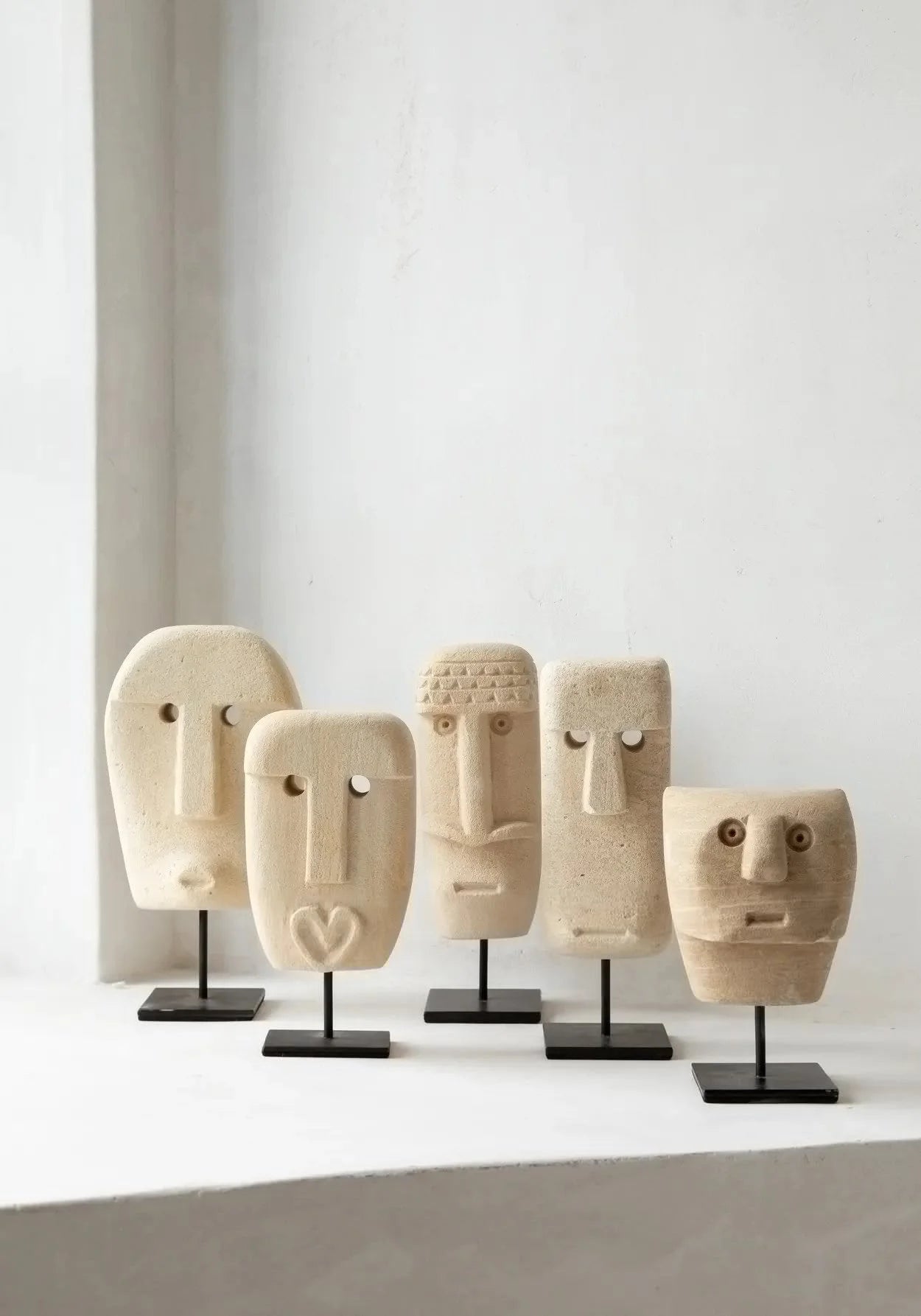 Série de cinq masques abstraits en grès ou bois sur supports noirs pour décoration intérieure