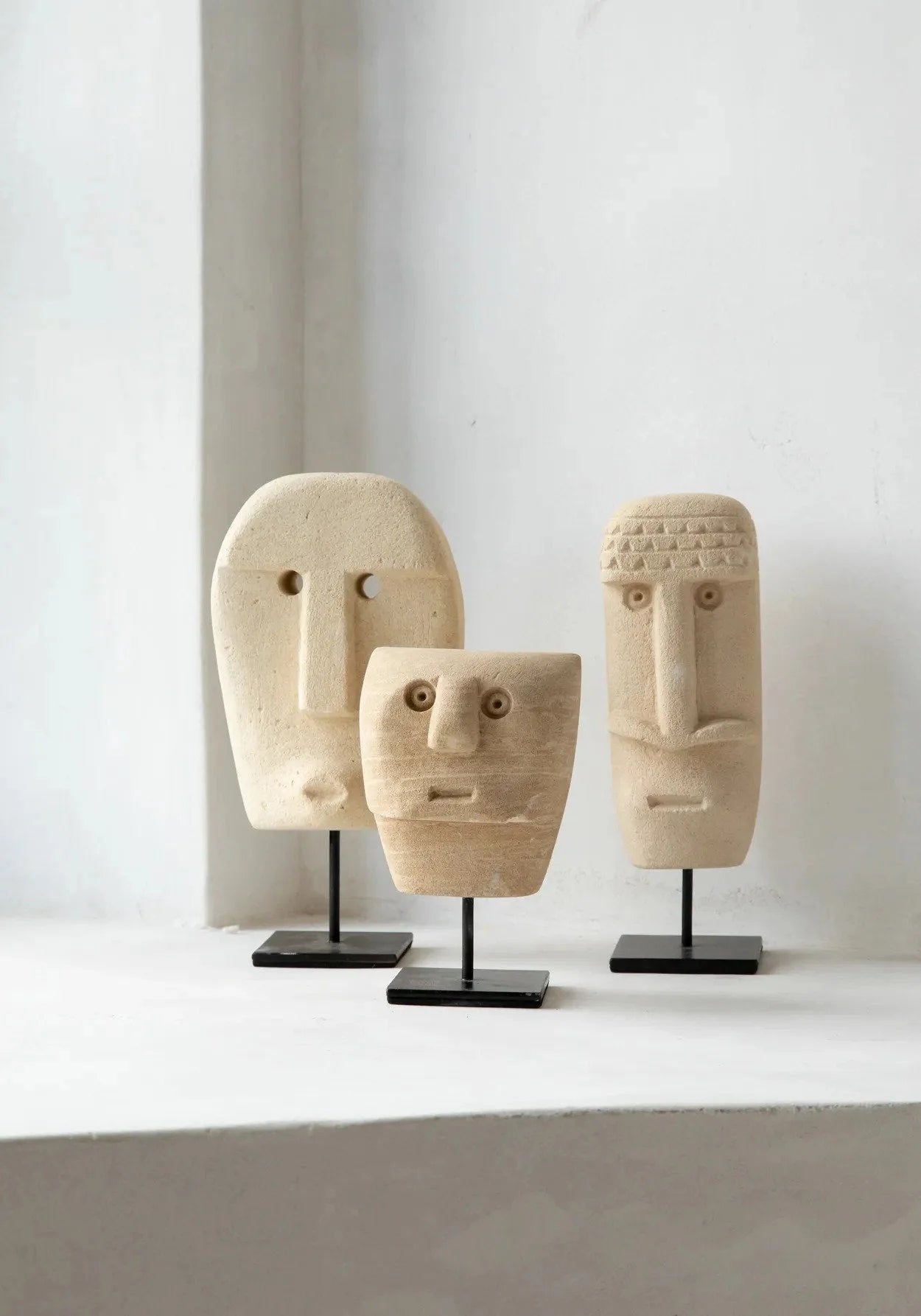 Trois sculptures en bois sculpté visage sur socles noirs, Statue en grès Sumba