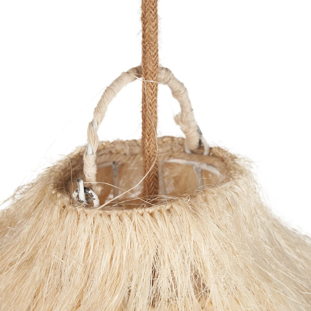 Femme aux longs cheveux blonds ondulés assise sur canapé beige près de suspension cloche frangée en fibres naturelles coloris paille Ø60 cm