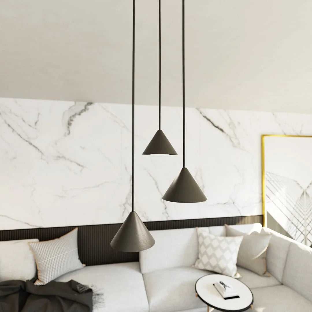 Trois suspensions coniques en métal noir mat, H100 cm, contre mur marbre blanc