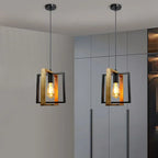 Suspension métal noir et bois installée dans un salon avec lumière tamisée, ambiance industrielle et chaleureuse.