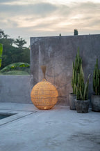 Suspension ovale en rotin naturel ajouré avec lampe sphérique extérieure à l’intérieur