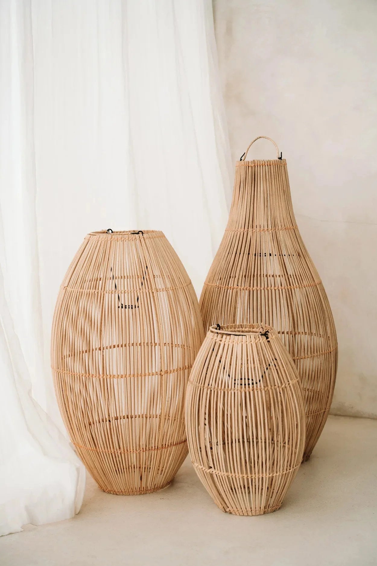 Suspension ovale en rotin tressé naturel avec trois lanternes en rotin de hauteurs variées