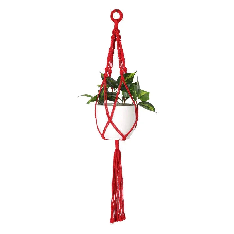 Suspension en macramé rouge à franges longues avec pot blanc et plante verte