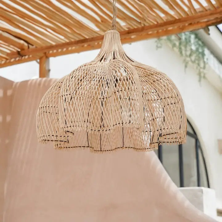 Suspension en rotin en forme de fleur sous une pergola en bois naturel.