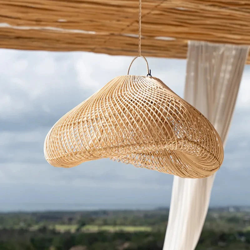 Suspension en rotin en forme de nuage dans un salon lumineux avec vue panoramique.