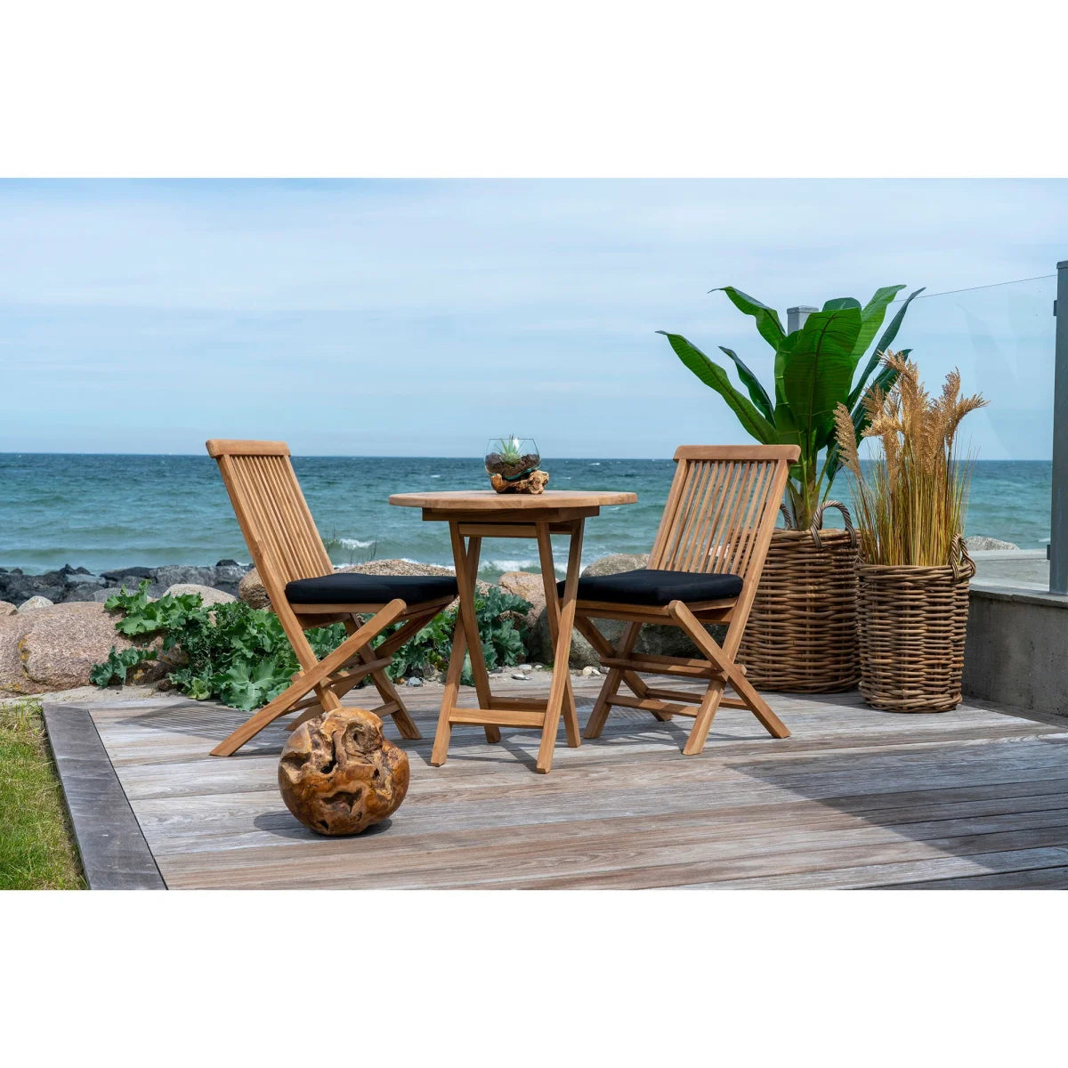 Chaise pliante en teck avec coussin noir et dossier ajouré