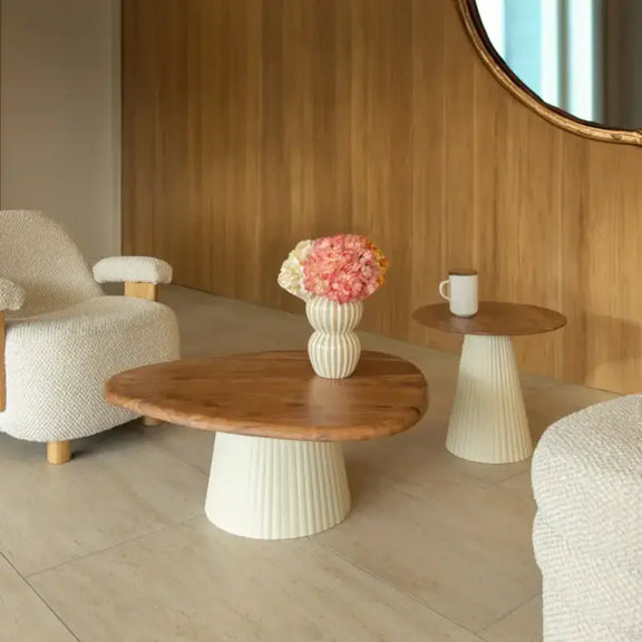 Table basse en bois d'acacia et pied en métal écru mise en situation dans un salon cosy.