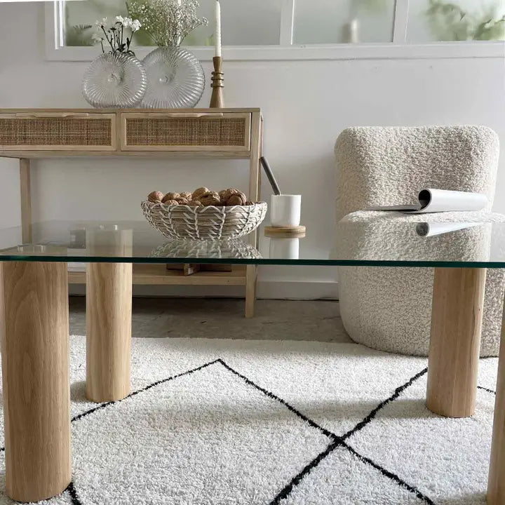 Vue de face de la table basse rectangle avec un plateau en verre trempé et pieds en bois naturel.