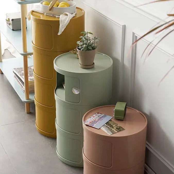 Ensemble de tables de chevet minimalistes jaunes, vertes et roses, intégrées dans un décor moderne.