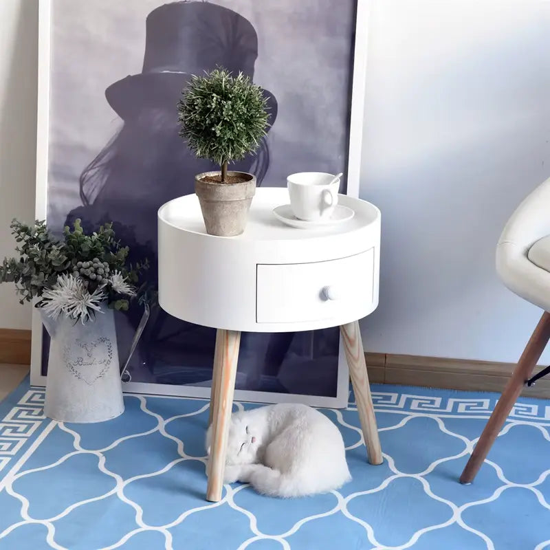 Table de chevet ronde scandinave blanche, décorée avec une plante en pot et une tasse, placée dans un intérieur moderne.
Image 2 :