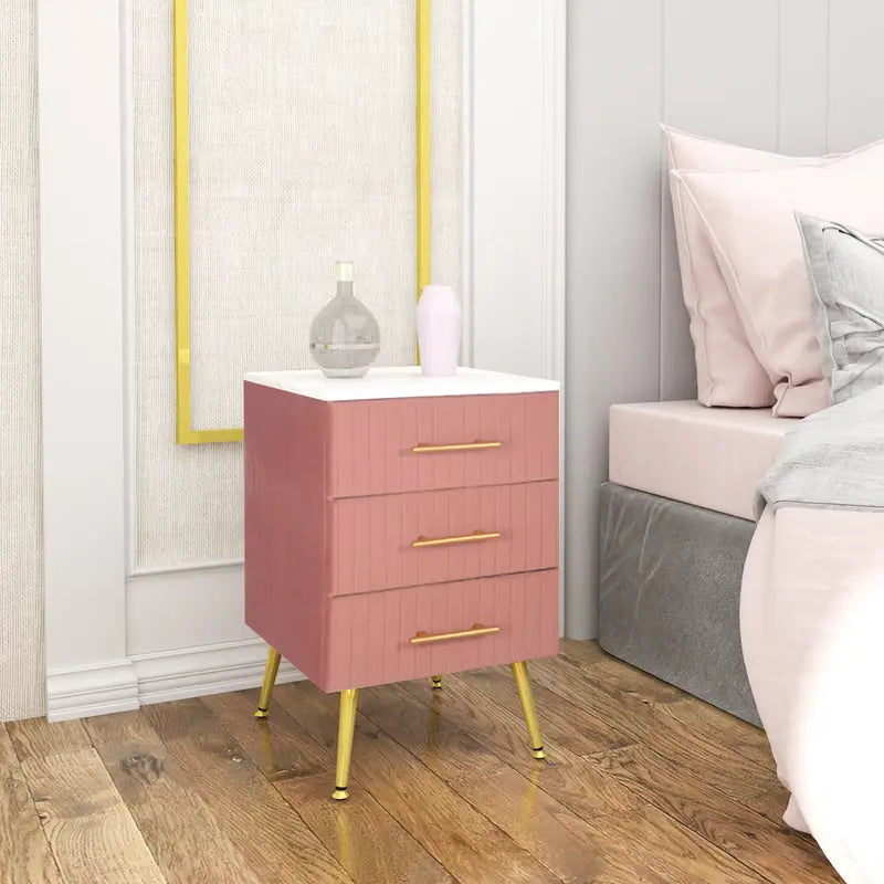 Table de chevet en velours rose élégante avec 3 tiroirs, parfaite pour compléter une chambre moderne et raffinée.