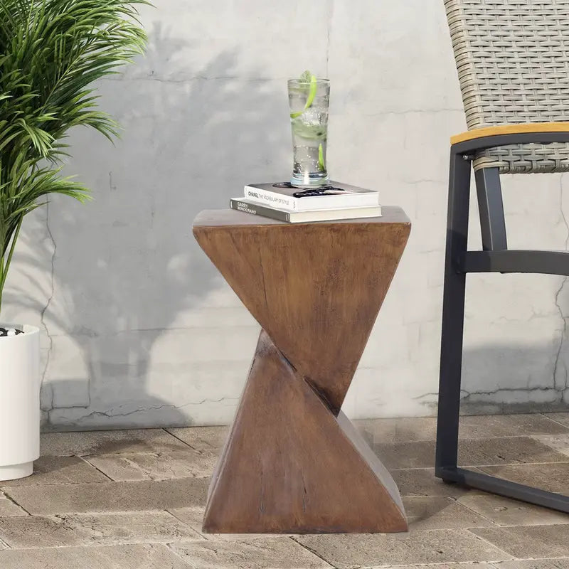 Table d’appoint moderne sur un balcon avec des livres et un verre posés dessus.