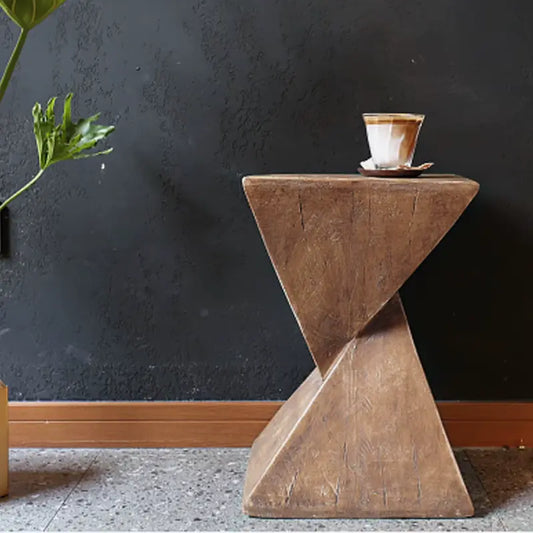 Table d’appoint moderne avec une plante et un verre dans un décor minimaliste.