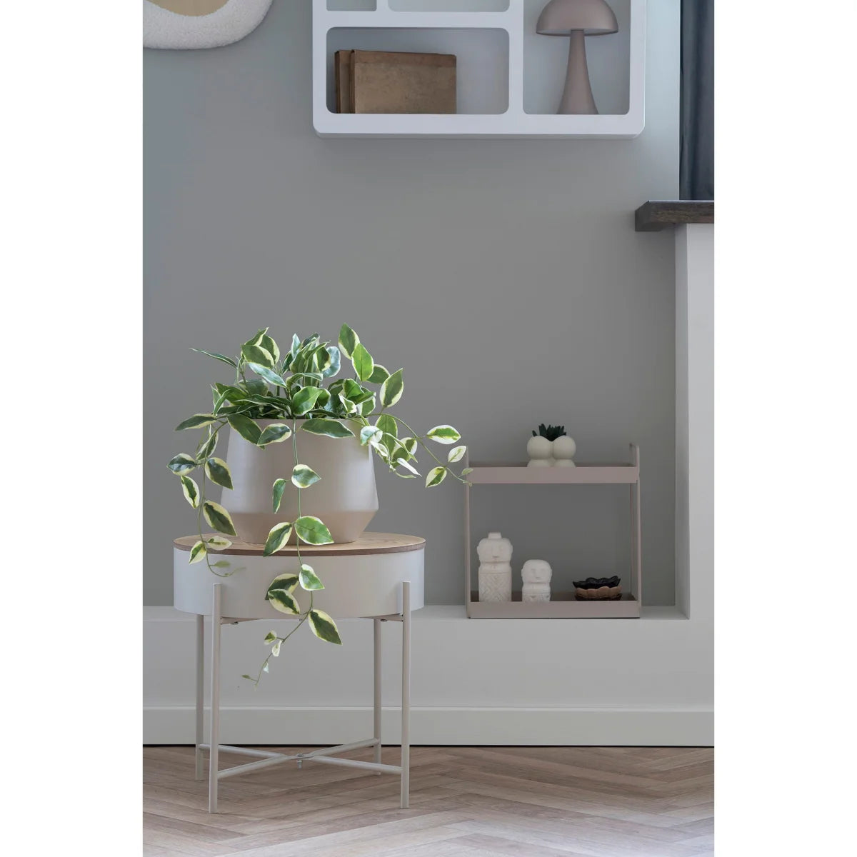 Pot en céramique blanche lisse avec lierre panaché vert et crème sur table ronde en acier beige gris Ø40 cm