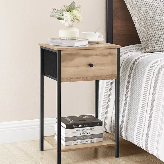 Table de chevet en bois avec un tiroir, décorée avec des fleurs et des livres.