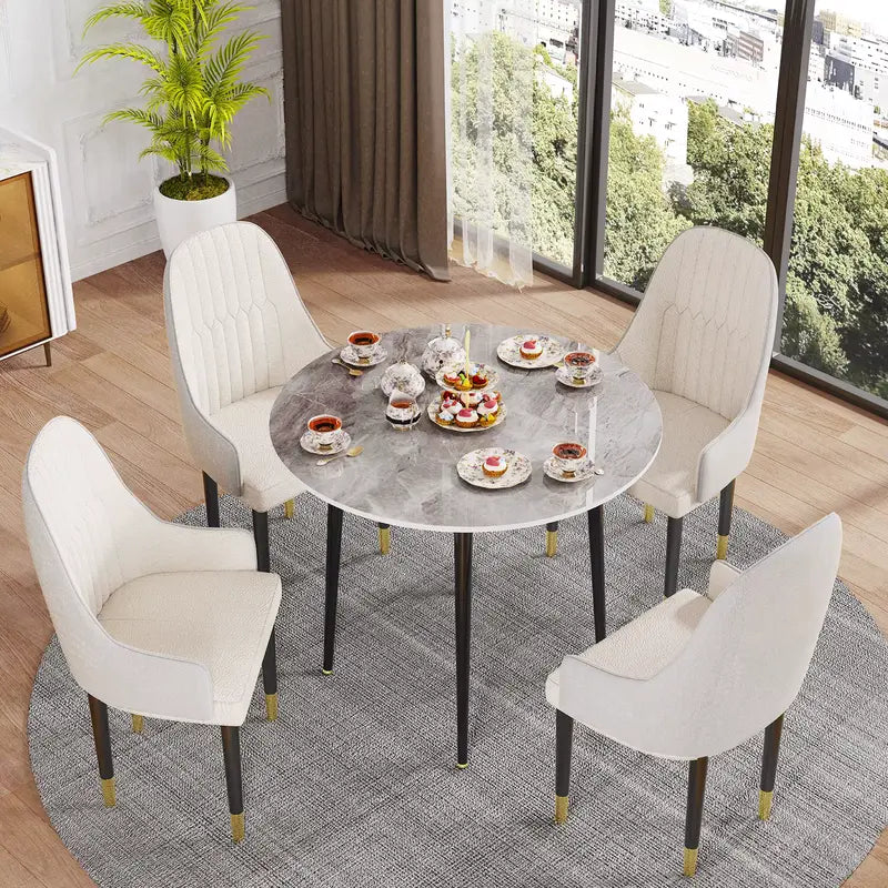 Table à manger ronde avec un plateau effet marbre gris et pieds en métal noir.
