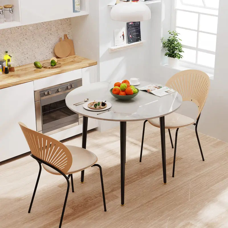 Table ronde effet marbre entourée de chaises scandinaves dans une salle à manger élégante.