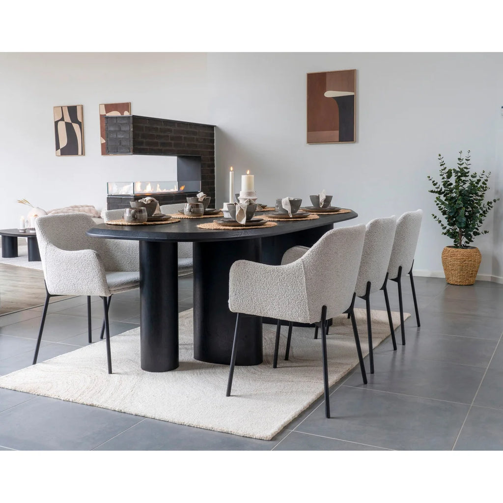 Table basse ovale noire design minimaliste avec tapis en laine beige ivoire motifs ondulés