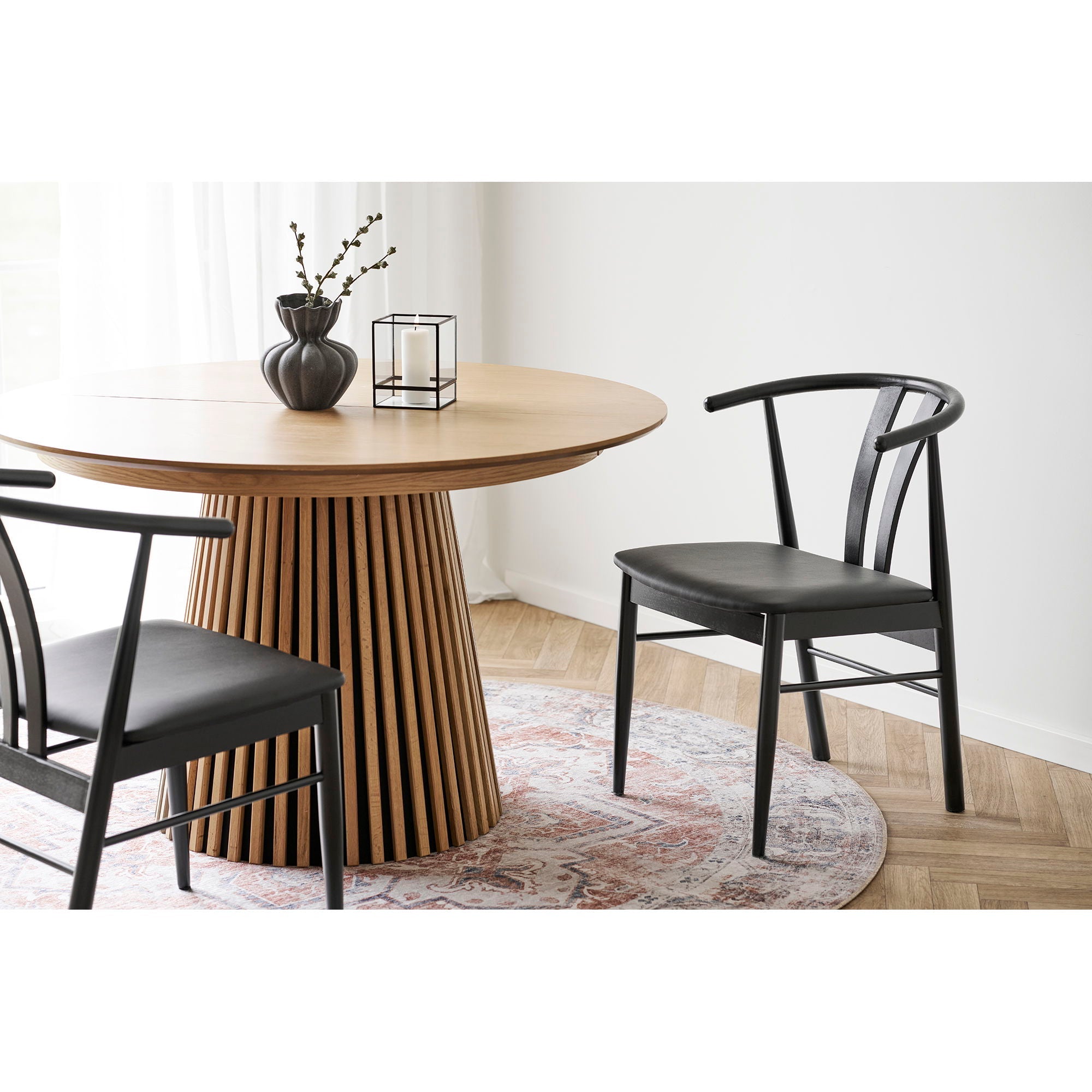 Chaise de salle à manger moderne noire en bois, dossier courbé élégant et siège rembourré, tapis rond persan orange et bleu Ø200 cm