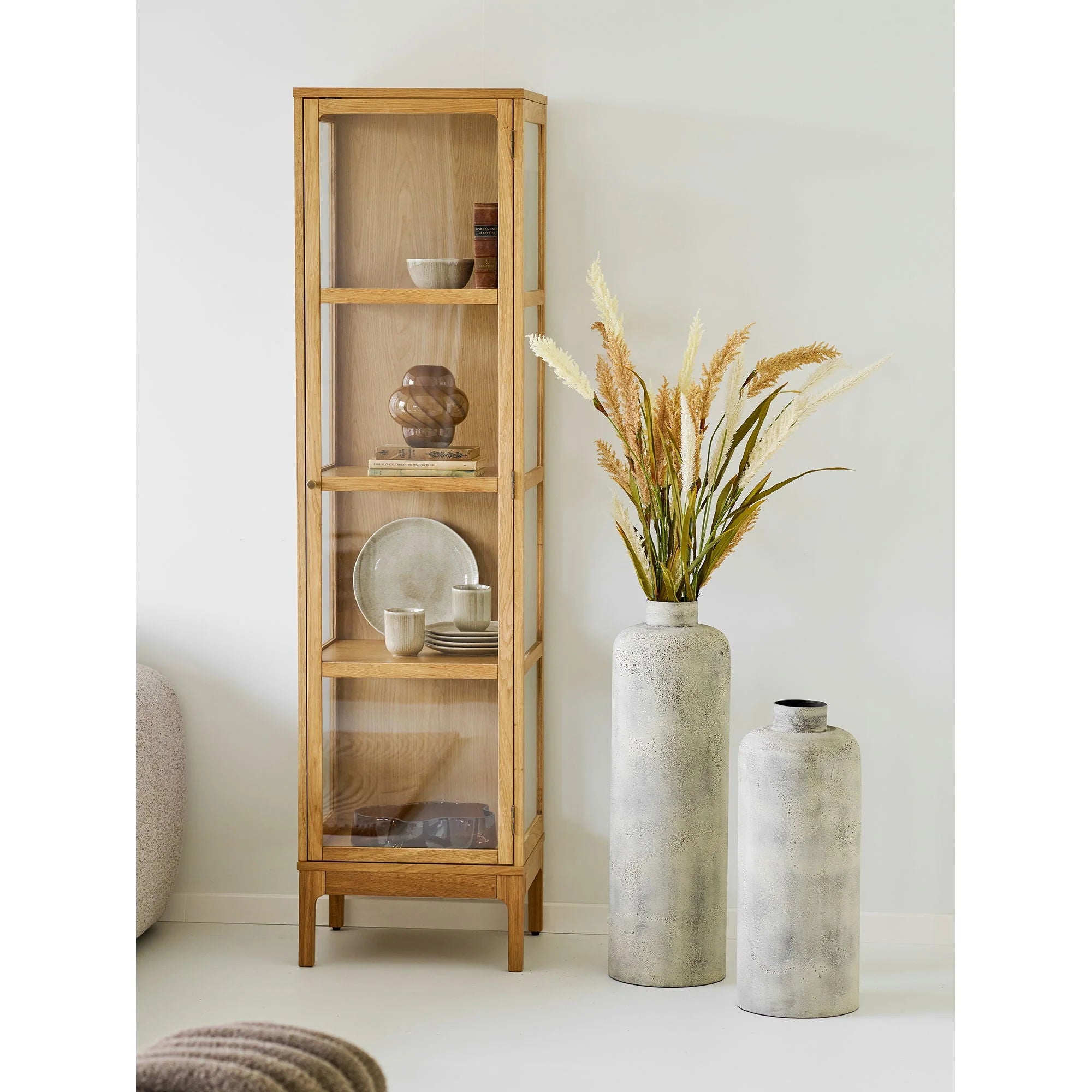 Vitrine en bois clair haut et élancée avec panneaux en verre