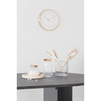 Horloge murale ronde en or, cadran blanc minimaliste, sur piédestal